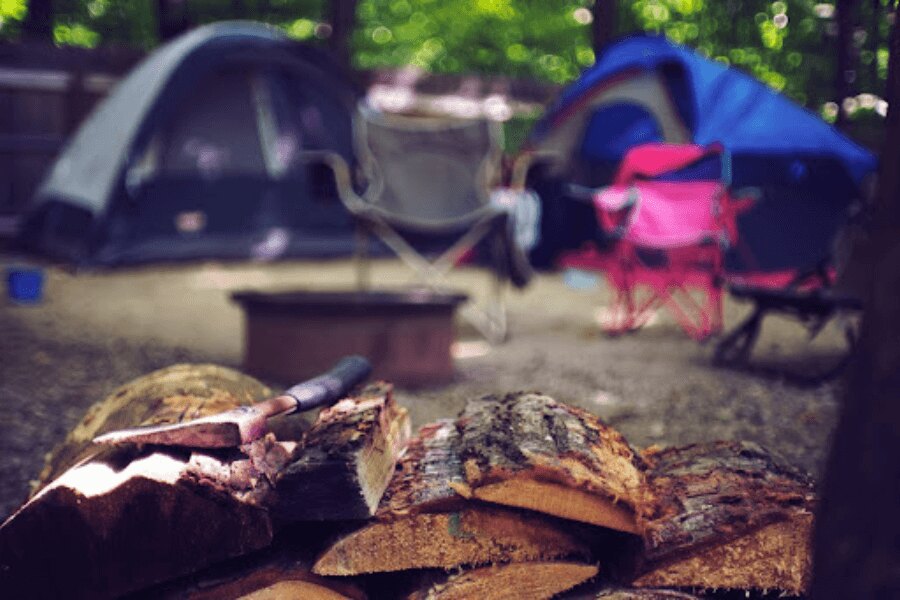 брадва върху дърво до къмпинг. Източник: https://www.pexels.com/cs-cz/foto/drevo-krajina-dovolena-leto-2662831/