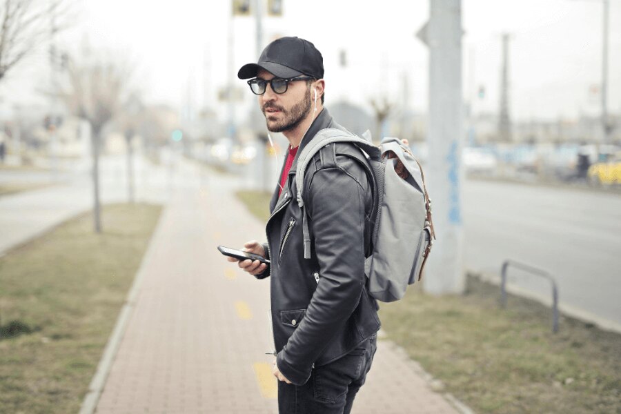 Мъж на улицата с раница и мобилен телефон. Източник: https://www.pexels.com/cs-cz/foto/845457/