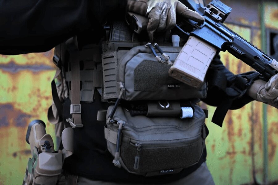 Мъж с Chest Rig Reaper™ Agilite Gear<sup>&reg;</sup> с патрондаши и с дълго оръжие. Източник: Rigad - видео