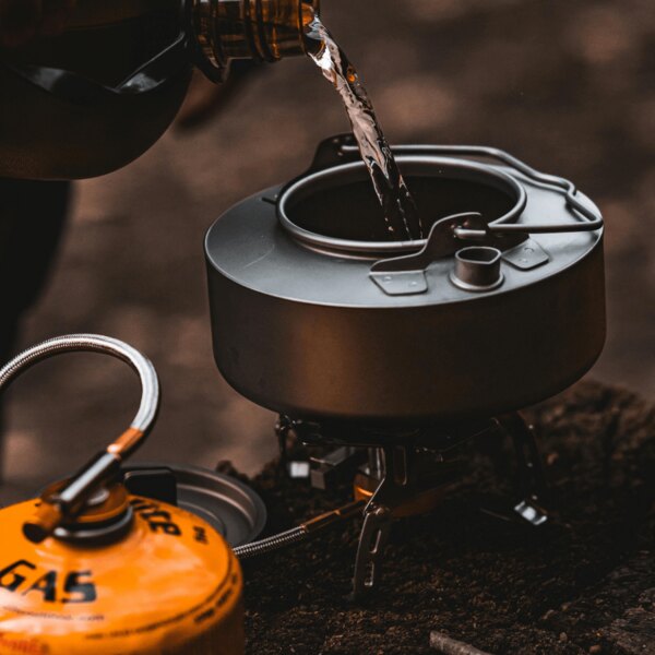 Готвене на открито сред природата. Източник: https://www.pexels.com/cs-cz/foto/voda-misa-kempovani-lahev-20397578/