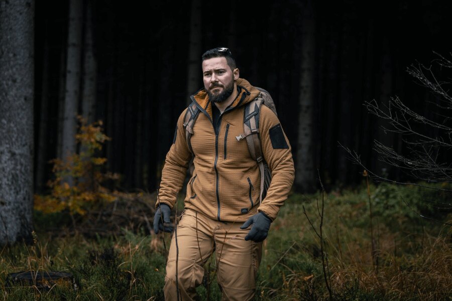Мъж в суичър Helikon-Tex Patriot Pro по време на поход в гората – демонстрация на леката и ветроустойчива конструкция Stormfleece<sup>&reg;</sup>. Снимка: Rigad