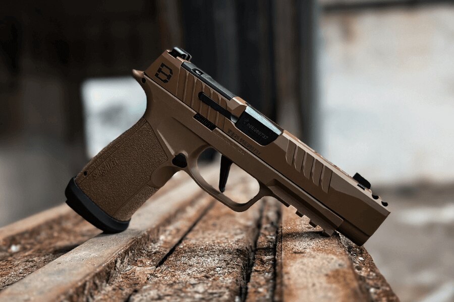 Съвременен самозареждащ се пистолет калибър 9 мм Luger положен върху дървена основа.