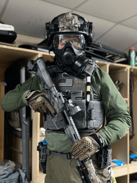 Член на оперативното звено, оборудван с каска Busch Protective, защитна маска и тактическо снаряжение.