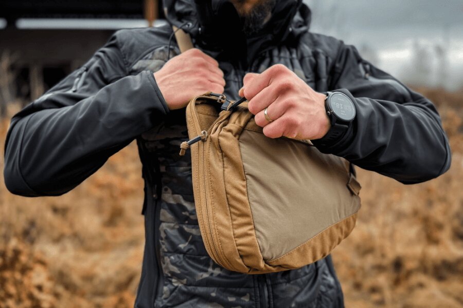 Отваряне на основния джоб на sling bag с едно движение на ципа преди изваждането на пистолета.